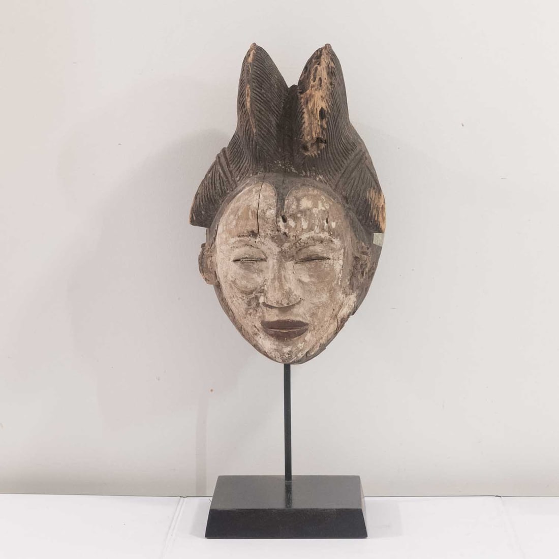 Early 20th C. African Punu Carved Wood Mukudj Mask, Gabon: Medium: Carved Wood Size: 7x7x17 inches Age/Detail: Early 20th C. African Punu Condition: cracks, check photo for condition reference. Provenance: Collection from Estate in Williamsburg Please view al