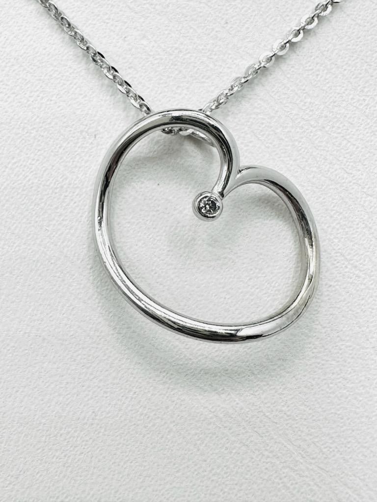14KT White Gold Natural Diamond Opened Heart Pendant and Chain # 2039: # 2039 14KT White Gold Natural Diamond Opened Heart Pendant and Chain 1 pc diamond 0.01 carat 16” chain with lobster lock clasp closure Pendant and Chain Weight: 2.50 grams Pendant size: 17 mm x