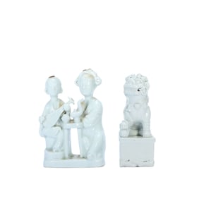 A Chinese porcelain figure and a porcelain lion