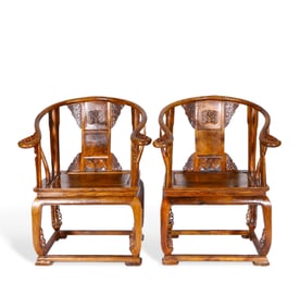 A pair of Chinese wooden round-backed armchairs