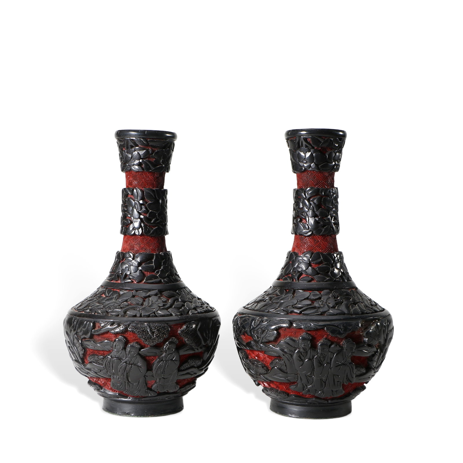 A pair of carved lacquer vases: The exterior is black, with hollow carvings revealing the red paint inside, 19 cm high and 11 cm in diameter.