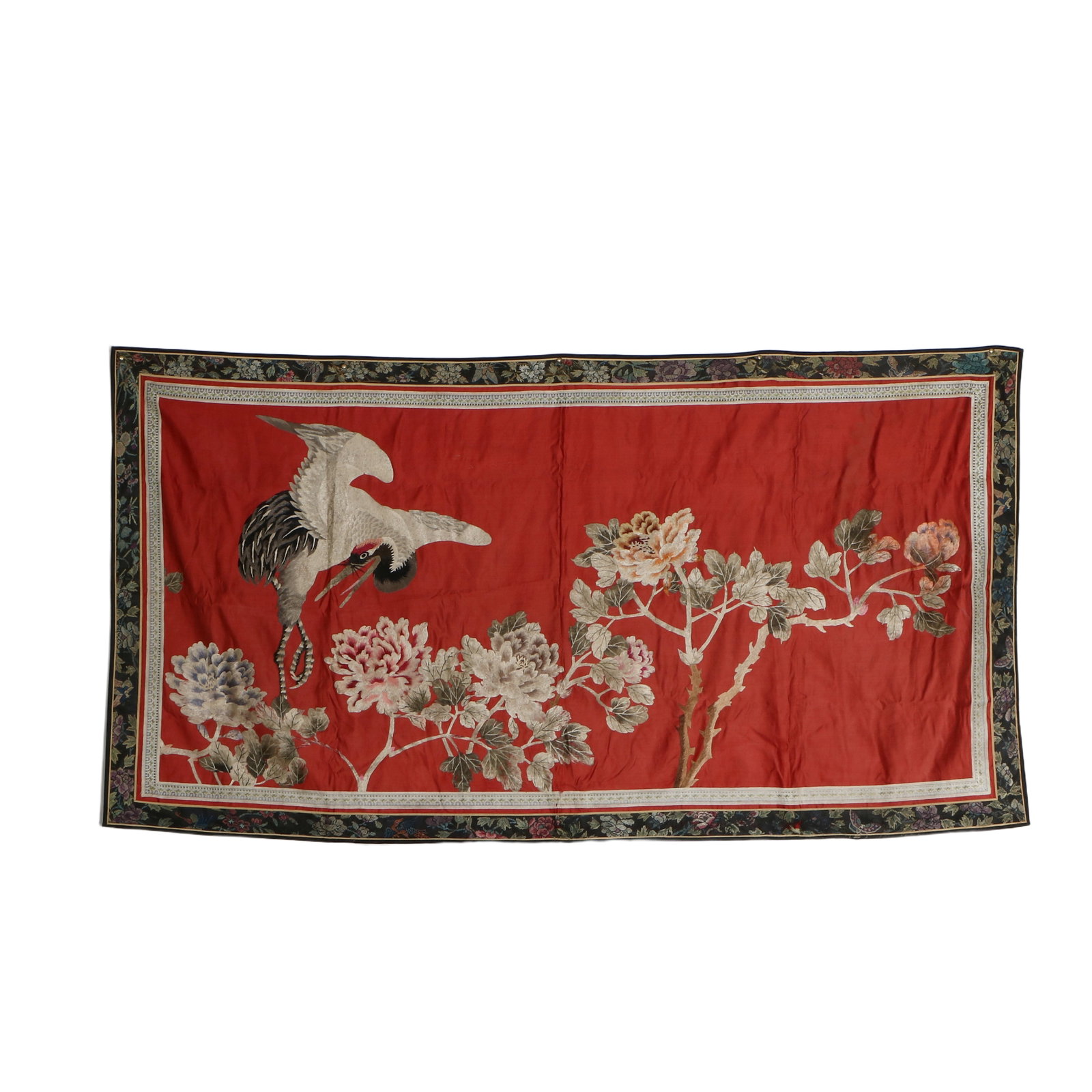 A Chinese embroidered hanging ornament: The embroidery features cranes and peonies. Height 85cm, width 88cm.