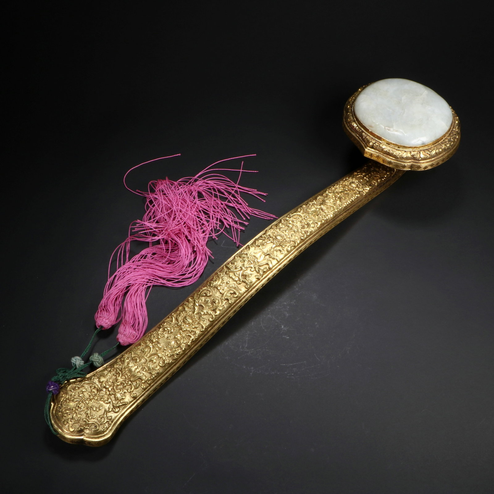 A Qing dynasty gilded bronze ruyi ornament inlaid with jade: The handle is entirely carved with patterns. Height 5.5 cm, length 36 cm, head width 9 cm.