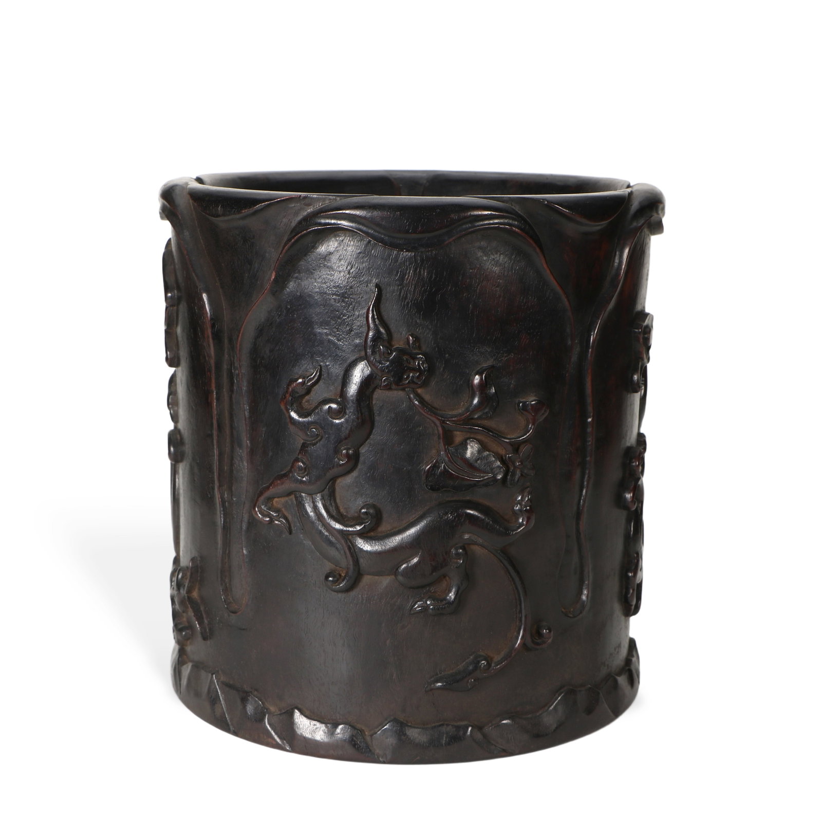 A Qing Dynasty rosewood brush pot: The exterior of the pen holder is carved with a dragon, 22.5 cm tall with a 21.5 cm diameter.