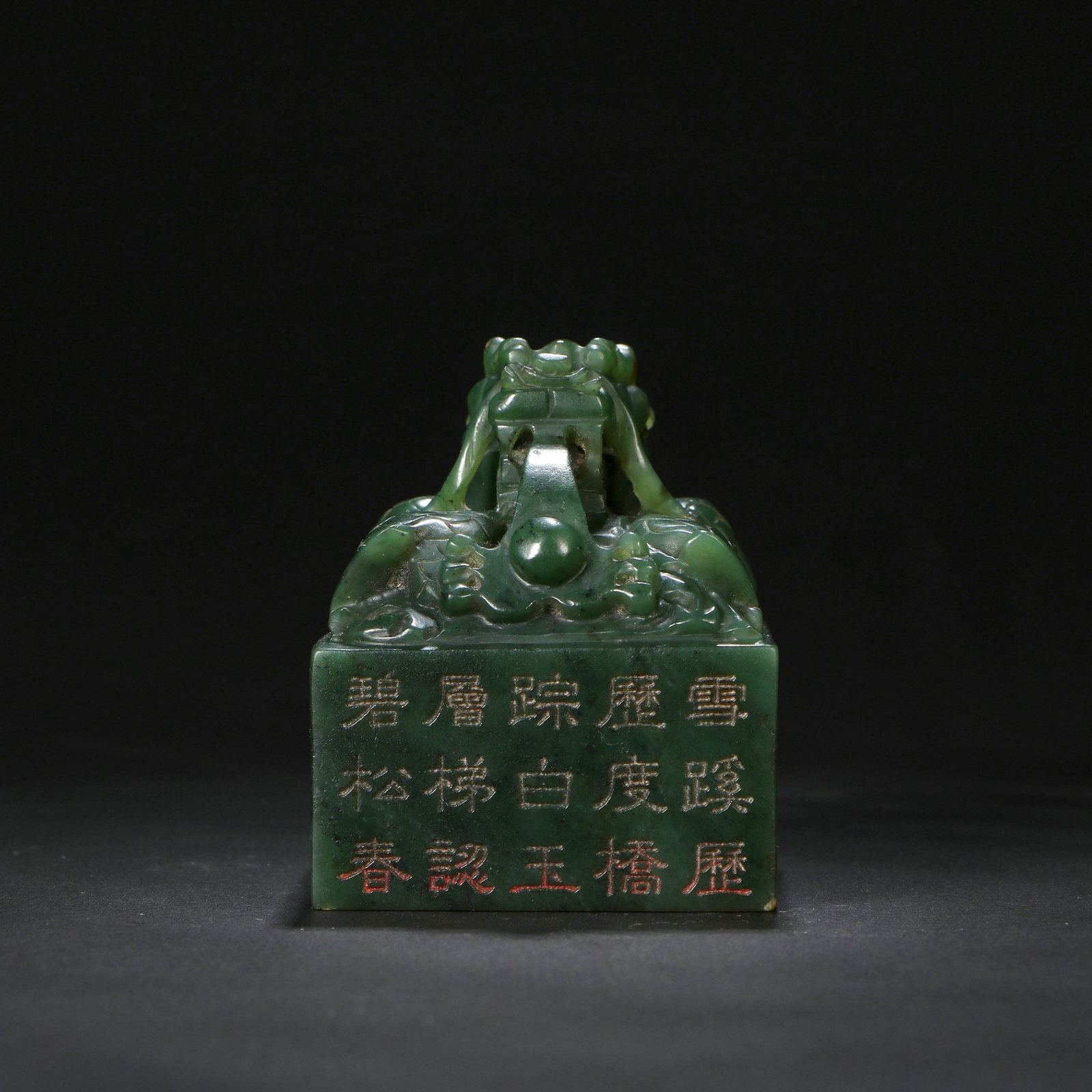 A Hetian jade seal: The upper part of the seal is carved with a dragon, and there are characters carved on the side. Height 5cm, length 4cm, width 4cm.