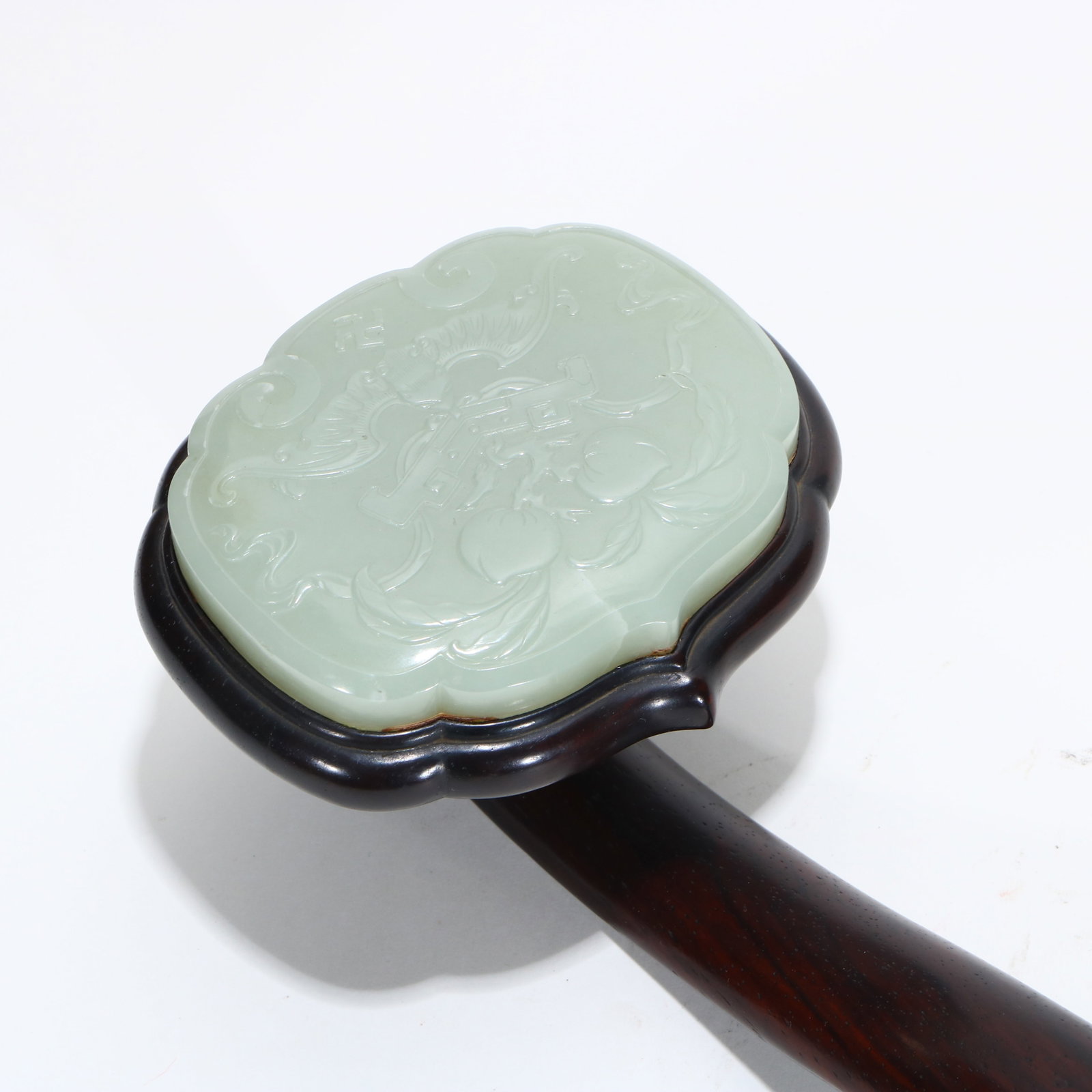A rosewood ruyi inlaid with jade: All three jade pieces are carved with patterns, measuring 47.5 cm in length and 10.5 cm in head width.