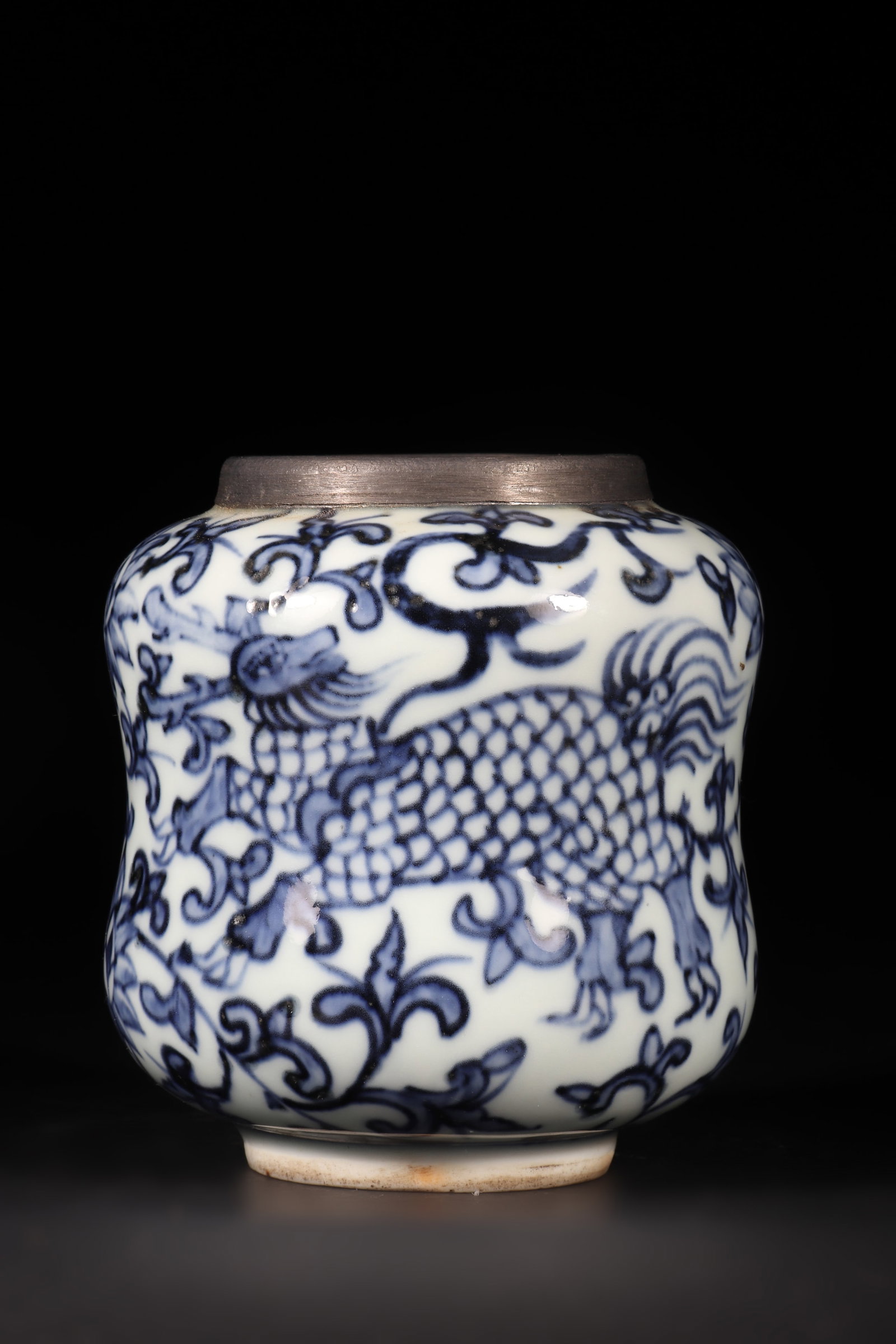 A Blue and White Porcelain Jar: A blue and white porcelain jar with auspicious beasts and floral patterns, the jar mouth wrapped in tin. H: 9cm D: 8.5cm (Max)