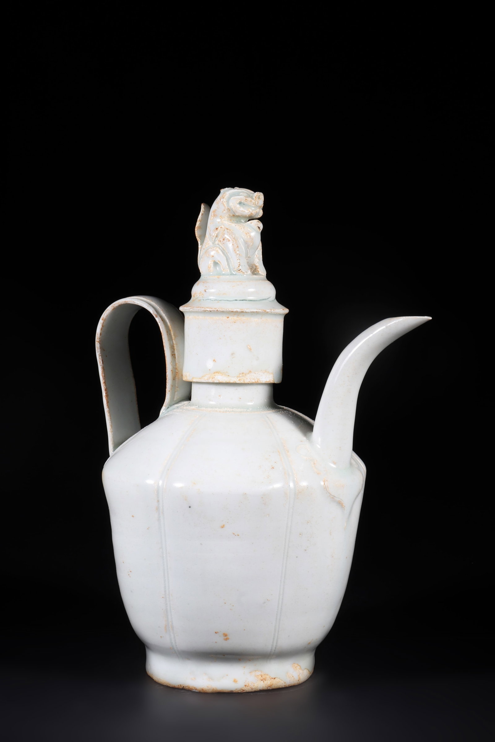 A White Glazed Wine Pot: A white glazed wine pot with a ribbed body and a auspicious beast shaped cap. H: 22.5cm W: 17cm (Max)