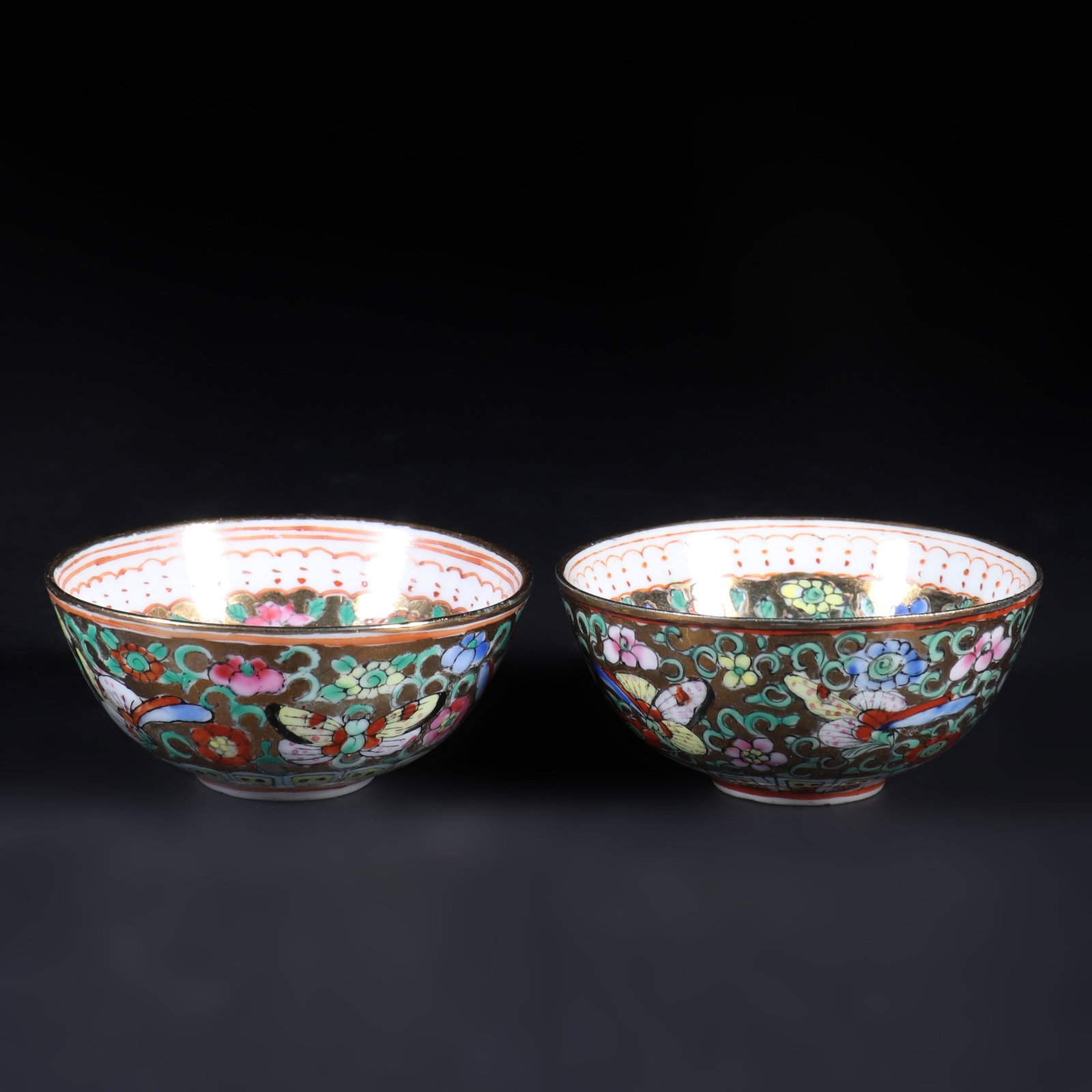 A Pair of Canton Porcelain Tea Cups: A pair of Canton porcelain tea cups, with colorful butterfly and floral patterns on the cup walls, a lady's pattern inside the cup, and the words "Guangcai" on the bottom of the cup. H: 2cm D: 5cm X2