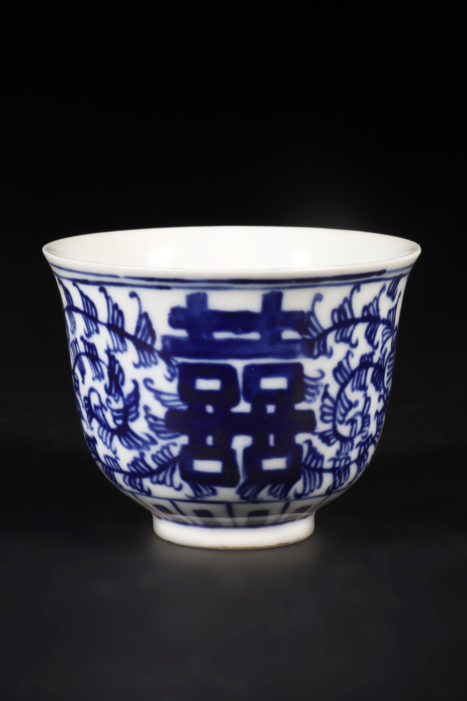 A Blue and White Porcelain Cup with The Words' Wan Yu ': A blue and white porcelain cup with the words "xi" and floral patterns on the cup wall, and the words "wan yu" on the bottom. H: 6cm D: 8cm (Max)