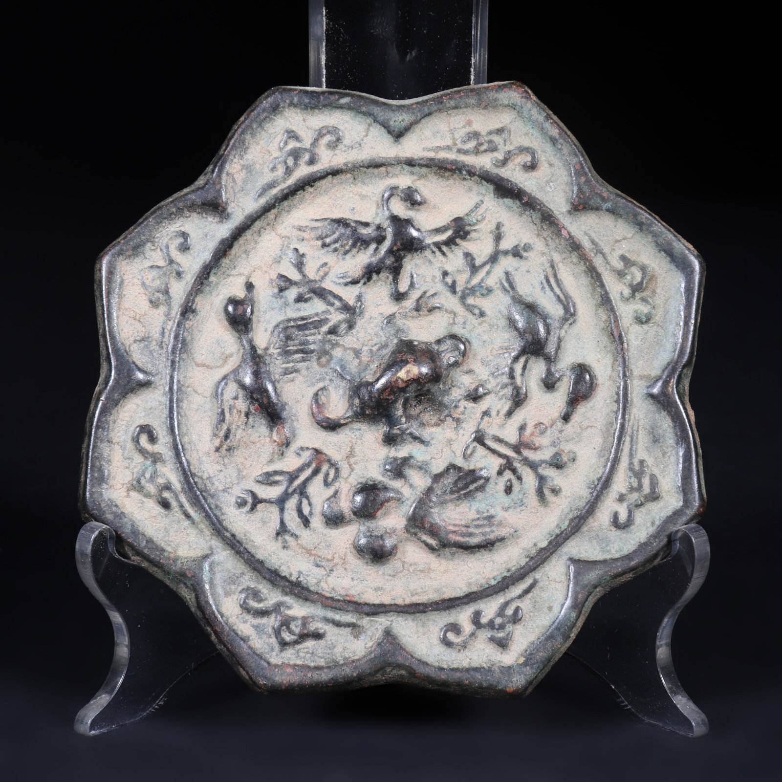 An Ancient Bronze Mirror: An ancient bronze mirror, shaped like a flower, with patterns of birds and auspicious beasts engraved on the back. D: 8.5cm (Max)