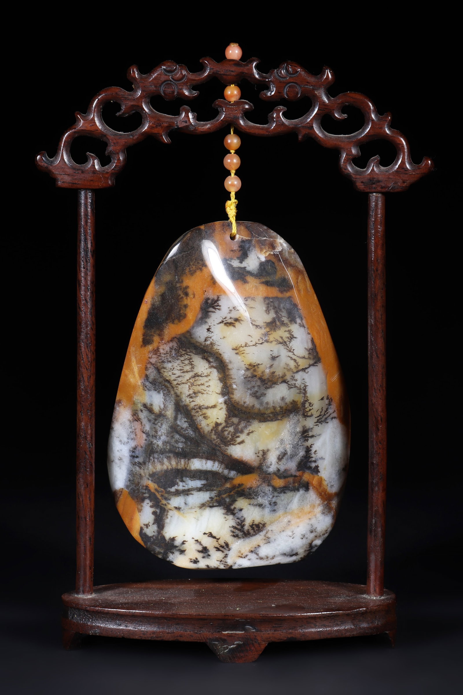 A Jade Ornament: A jade ornament with a wooden frame hanging a textured jade stone. H: 17.5cm W: 12cm (Max)