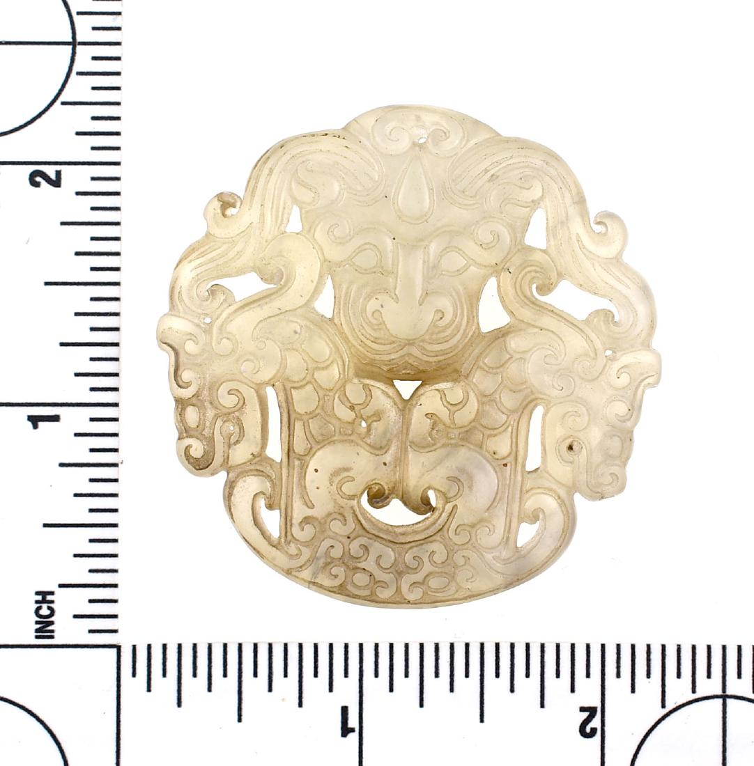 2 1/16" Chinese Pendant: Well executed Chinese pendant carved full three dimension on both sides. Very translucent high quality stone with nice smooth polish. Features a fierce creature's face with two conjoined dragons. Very