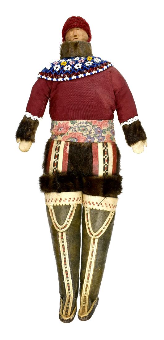 14" Greenland Inuit Doll: Superb example with sealskin boots and mittens with fur leggings with cloth top. Beaded drape. Carved Wooden face. Early 20th Century. Ex - Montgomery County Library Collection.