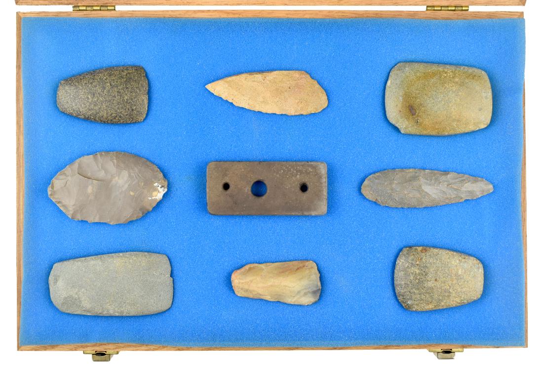 12x18 display of 9 Ky Artifacts: Stone Celts, Flint blades. Unusual gorget we don't believe is old. Lot being sold as Decorative only. Whitesburg, KY estate Collection.
