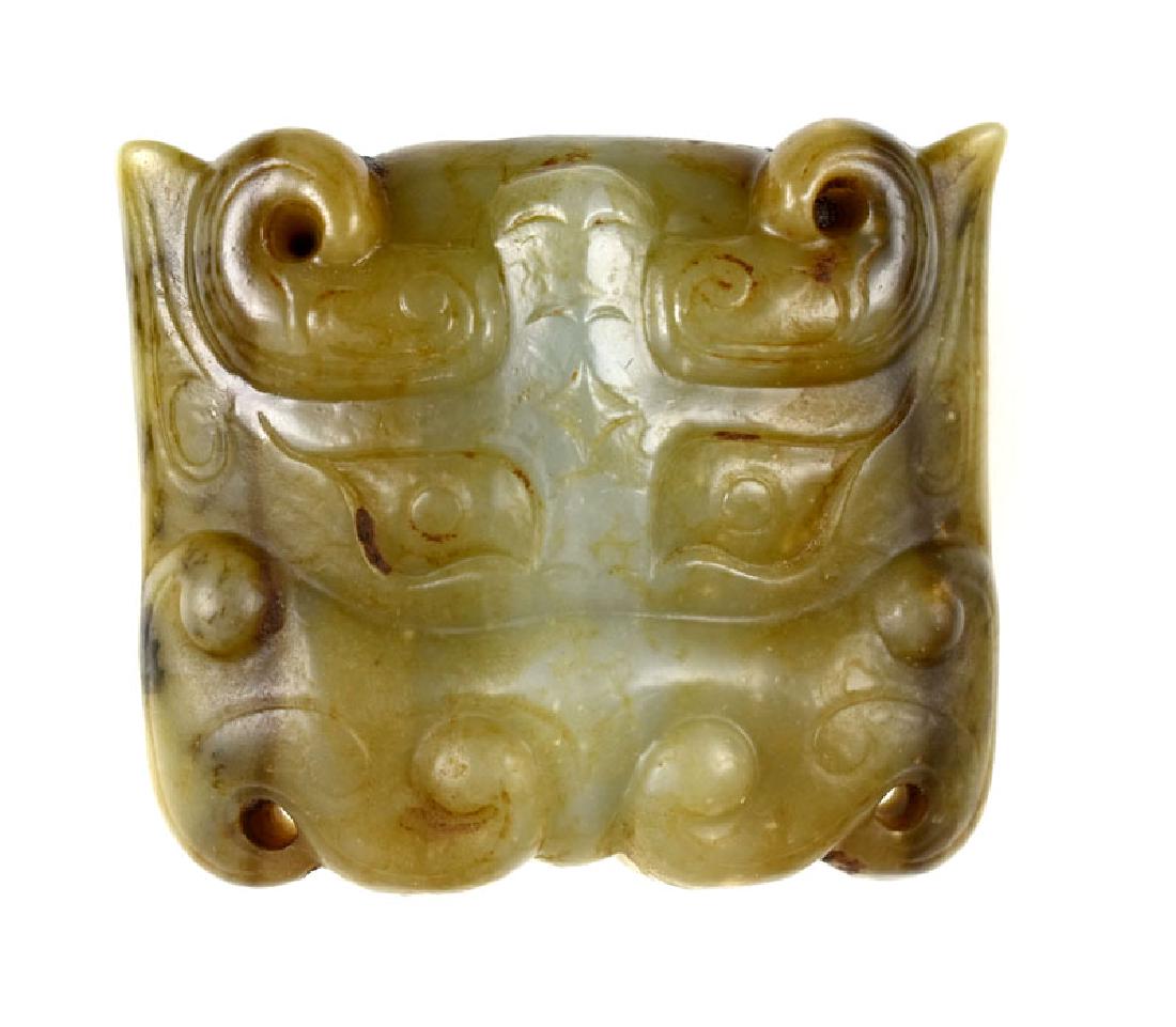 HAN DYNASTY JADE TAOTIE MASK OR FITTING: Han Dynasty Jade Mask or Fitting. This mask is intricately carved in extremely high relief with all the classic Taotie features such as eyes, horns, and a top jaw with no bottom half, like numerous ot