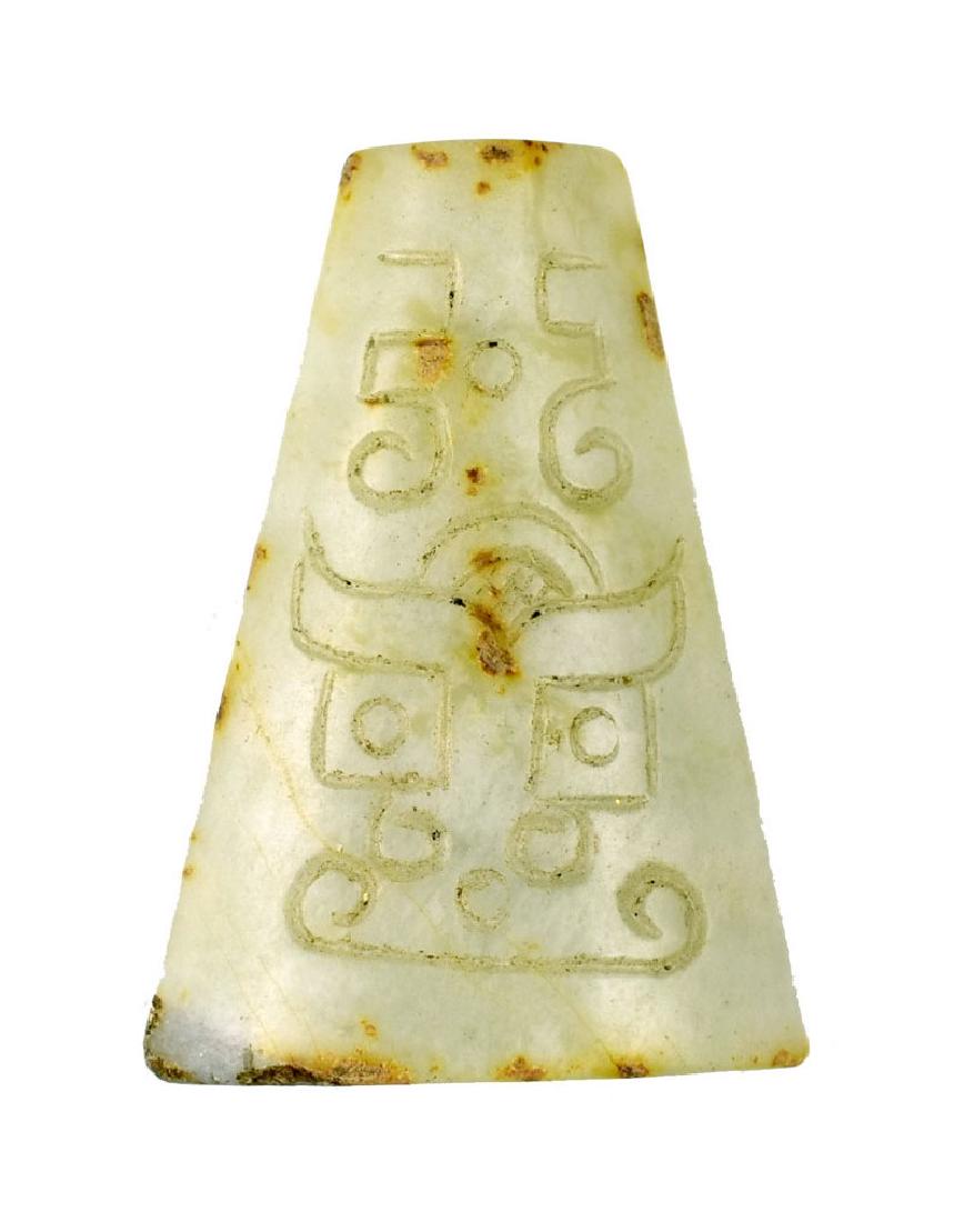 CHINESE ZHOU DYNASTY TAOTIE MASK TOGGLE: Extra Fine Zhou Dynasty Toggle. The surface carving covers both sides depicting classic Taoties with detailed eyes, jaws, horns and other stylized features and scrolling. The Jade itself is a whitish 