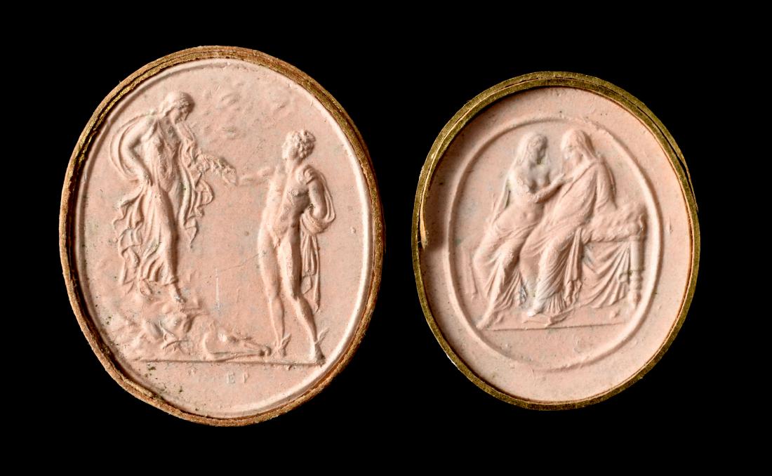 Pair of Grand Tour Plaster Cast Cameos: 19th Century Italian Grand Tour collection of two plaster casts of ancient Roman cameos bound in gilt-highlighted paper slips. They measure 1 5/16" and 1 3/16". One depicts Mercury and Pando