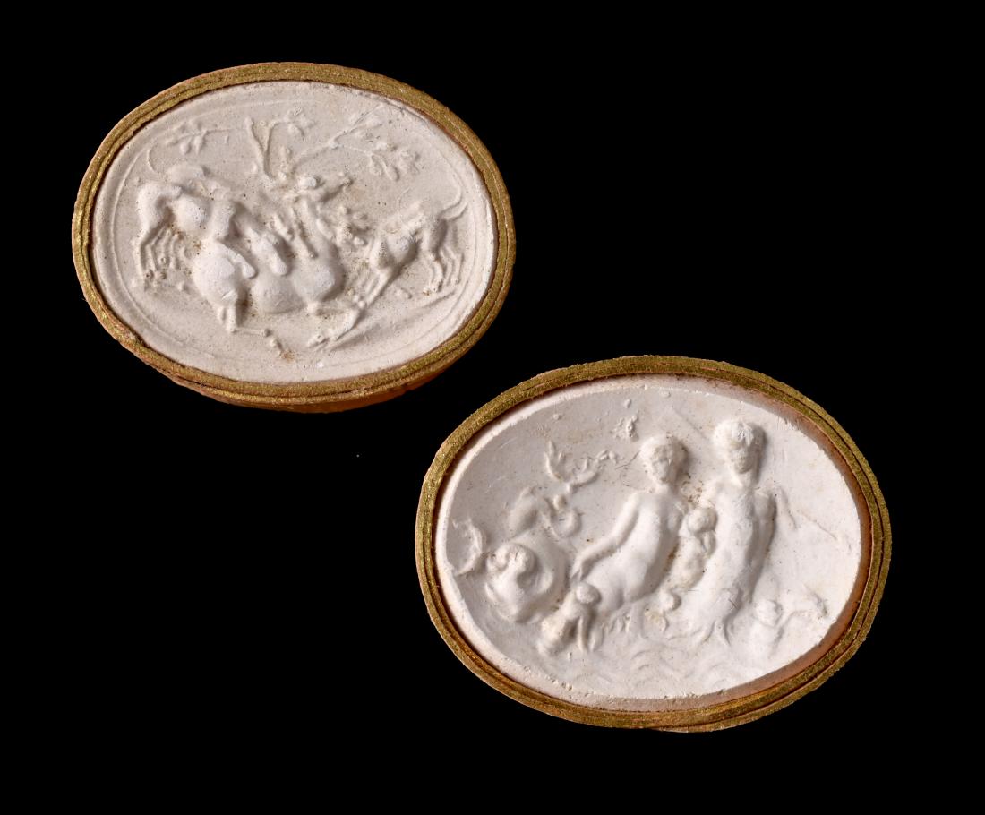Pair of Grand Tour Plaster Cast Cameos: 19th Century Italian Grand Tour collection of two plaster casts of ancient Roman cameos bound in gilt-highlighted paper slips. Measure 1 1/8" and 1 1/16". Neptune with Trident and Actaeon su