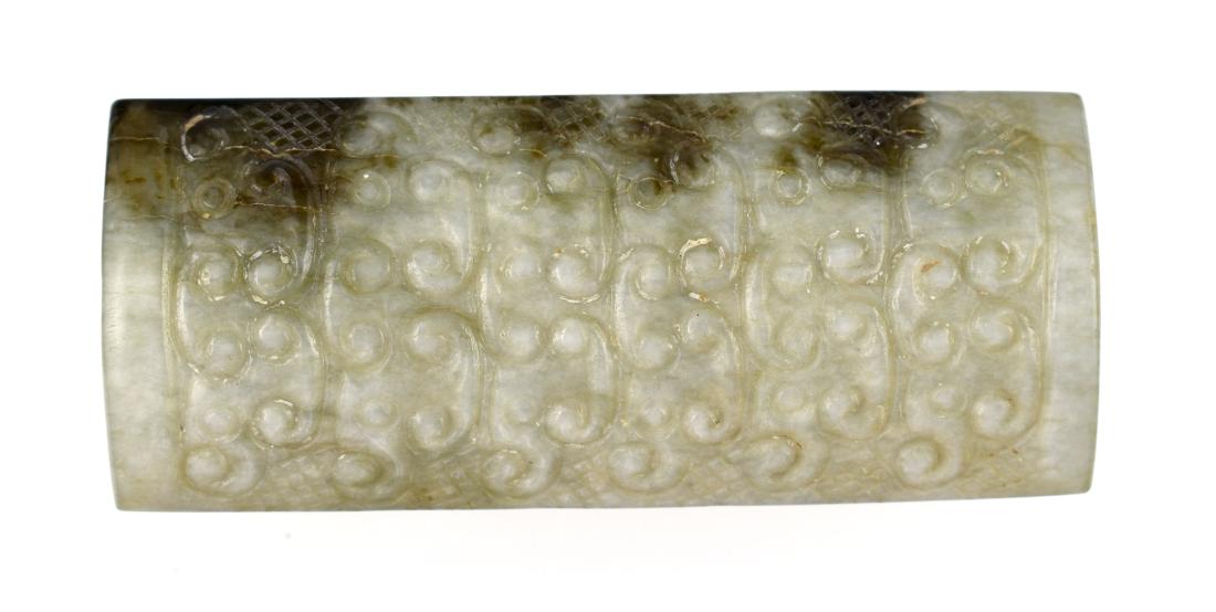 Antique Chinese Jade Toggle: Qing era example of an earlier Han era form. Meticulously carved clouds pattern on both sides. Made of a good sized block of two tone green Jade. Old style biconically drilled lenghtwise. Old sawing m