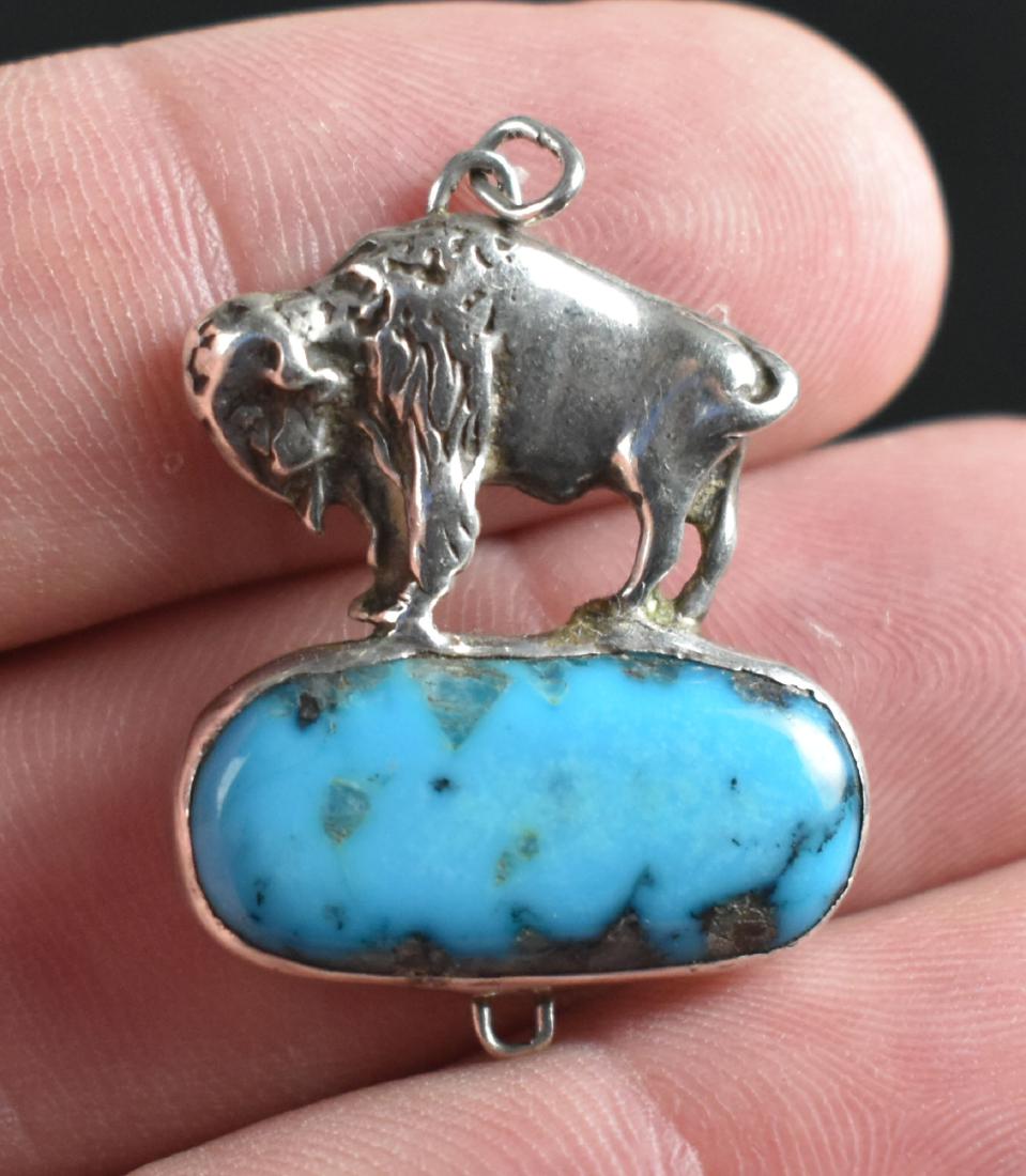 Sterling Silver Buffalo Pendant: Hallmarked 'RK' - perhaps an early Robert Kelley piece? Depicts a Buffalo atop a large turquoise stone. Weight 7.2 grams.