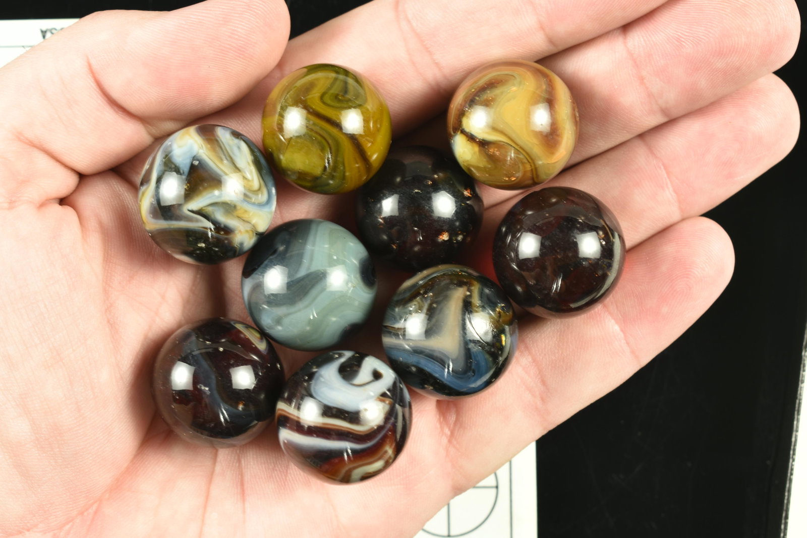 9 Vintage Swirled Marbles: Gorgeous lot of swirled marbles on deep red, brown, and blue-gray bases.