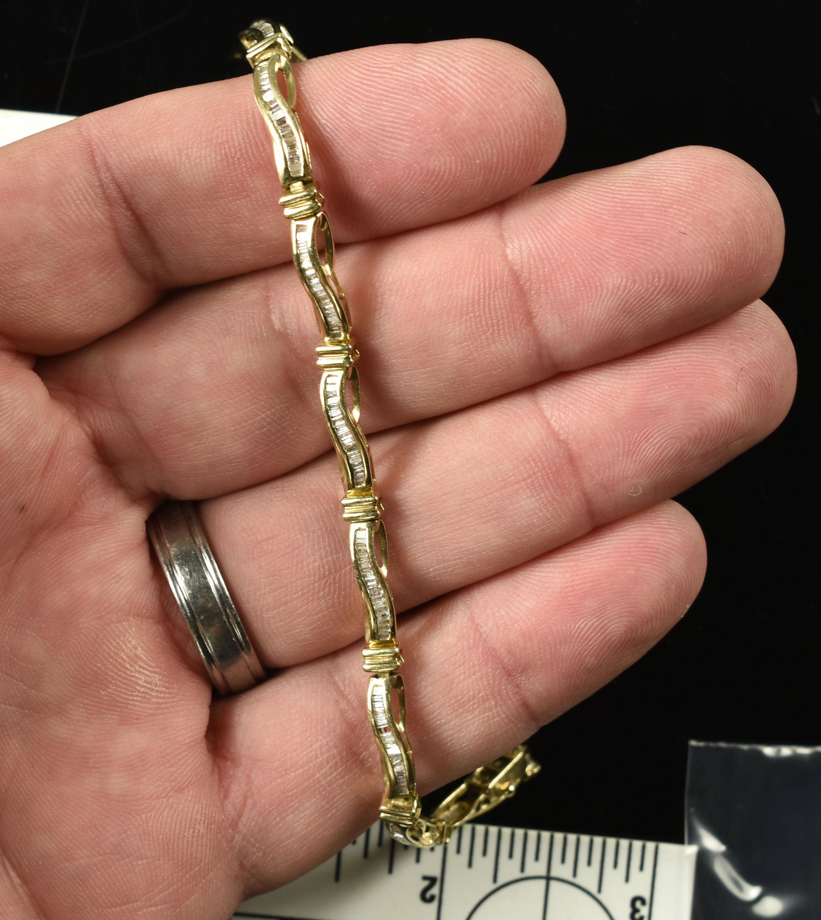 10k Gold Tennis Bracelet: Either CZ's or diamond chips in this 7.25" long bracelet. 8.4grams total weight. Clasp will need repaired.