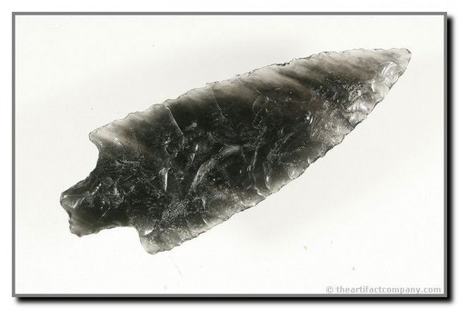 2 15/16" Gatecliff Split Stem: Precisely crafted and just gorgeous G-10 example. Translucent banded Obsidian with steaks running at a 45 degree angle. Found near Goose Lake in Lake Co., Oregon. Ex- Akers Collection.