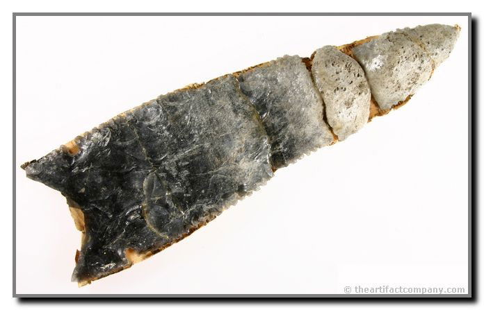 6 7/8" Stockton: MASSIVE finely made crematorial offering point with textbook serrations. The high heat from the cremation of this artifact caused the obsidian to melt, and trapped gases to expand and 'puff' up the ma
