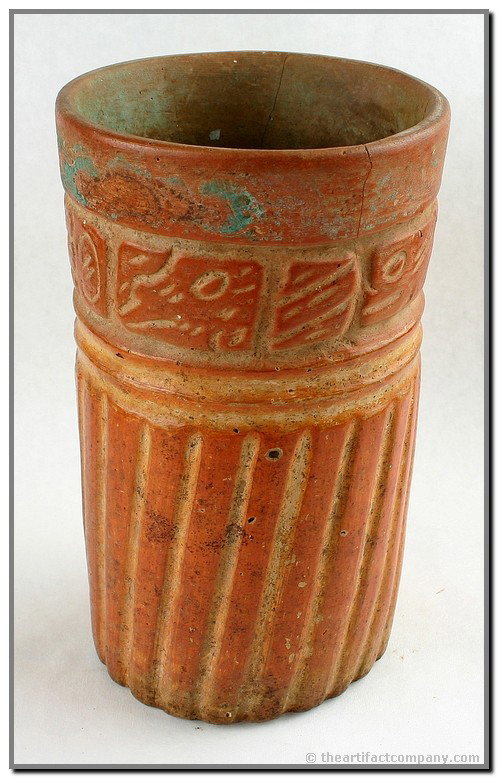 7 3/8" Mayan Cylinder Vessel: Truly exceptional. Late Classic Period circa 600 to 900A.D. Elegant orange ritual vessel with incised and fluted motifs and God glyphs around the exterior. Rare remnants of Mayan Blue paint still evid