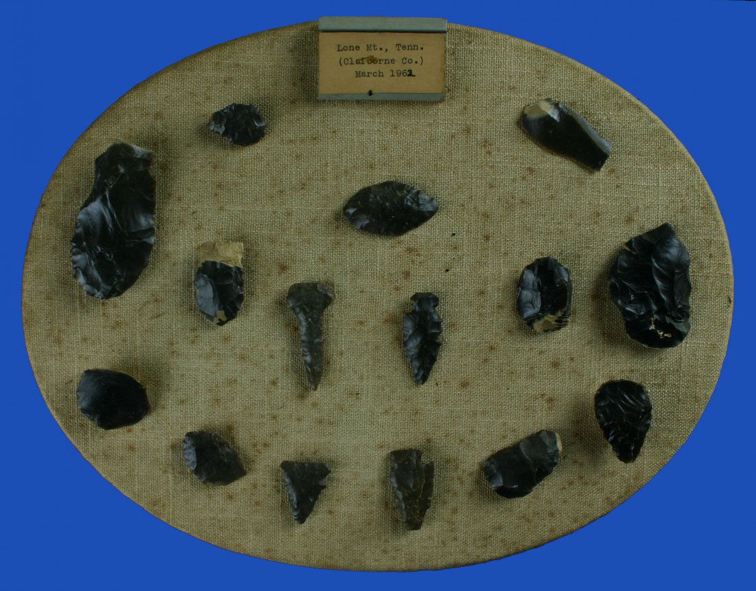 Plaque of 14 Artifacts: Nice display from the Joe Daugherty Collection of Knox Chert artifacts. Tag reads: ' Lone Mt. Tenn. (Claiborne Co.) March 1962'