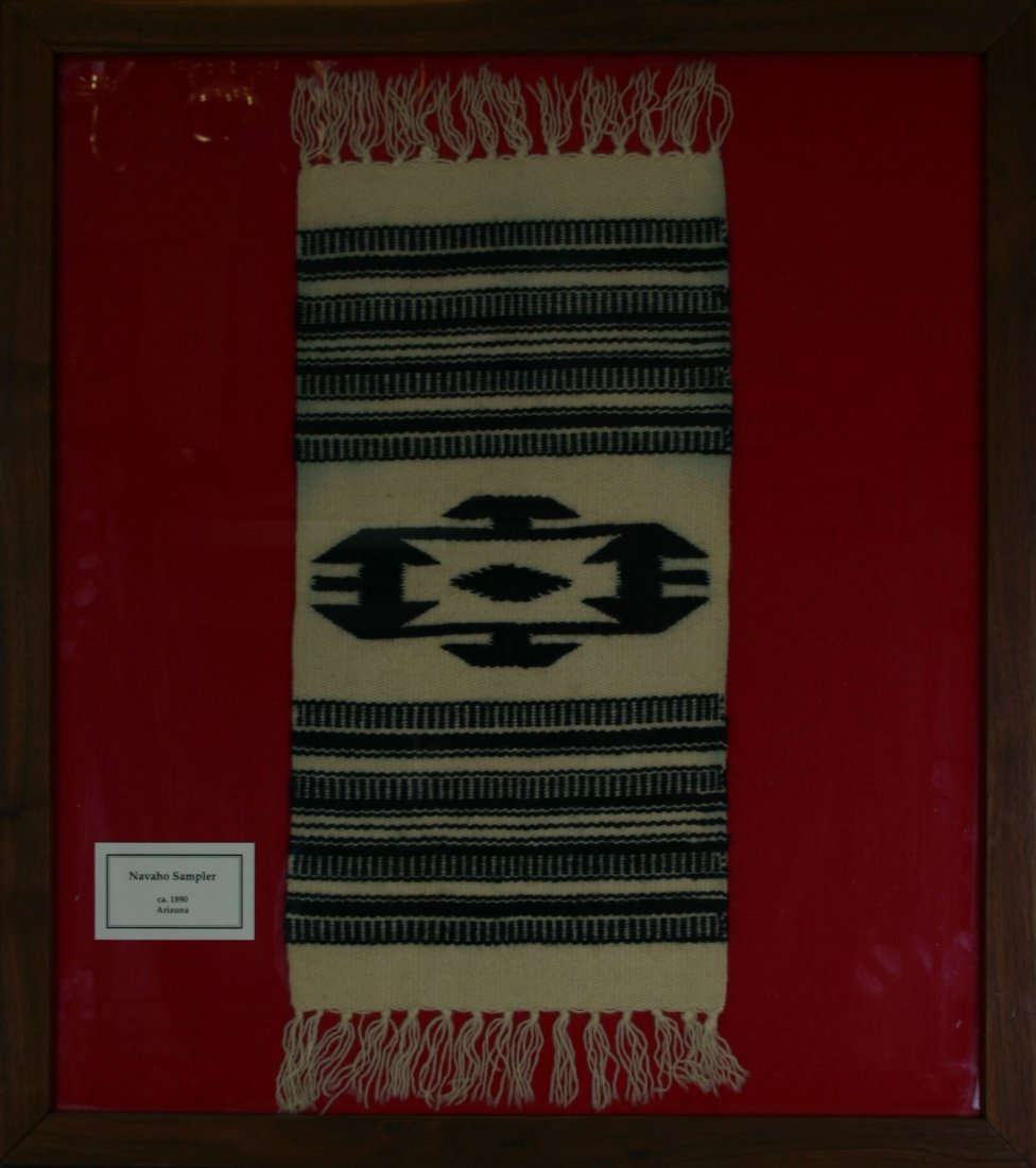 22 1/2x9 1/2" Framed Navajo Sampler 'Rug': Cream and black woven wool example from Arizona circa 1890 example framed under glass. Special shipping requirements.