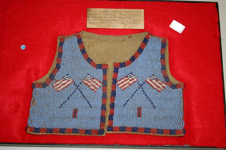8"x5 5/8" Beaded Sioux Infant's Vest: Interesting example with flags. Note lists it as Reservation period from South Dakota. Pretty.