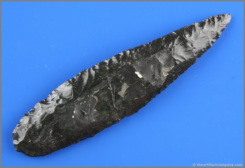 Outstanding 5 3/8" Cascade Knife: Glossy Jet Black Obsidian. Well flaked and exhibits a heavily ground basal stem. Blade has a slight curve, typical on a example this size. Ex- Reg Seely Collection. Lake Co., Oregon.