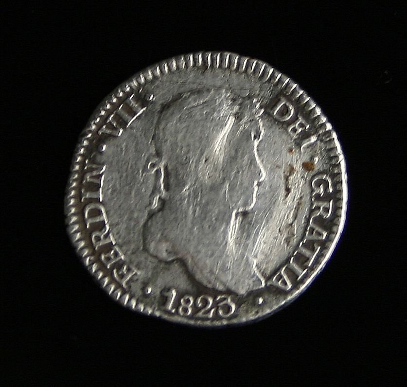1823JP Colonial Spanish 1 Reale Silver Coin: Ferdinand VII. Coins of this type were used in the United States pre/post Revolutionary war as legal tender. Nice example with good lettering. Lima, Peru Minting.