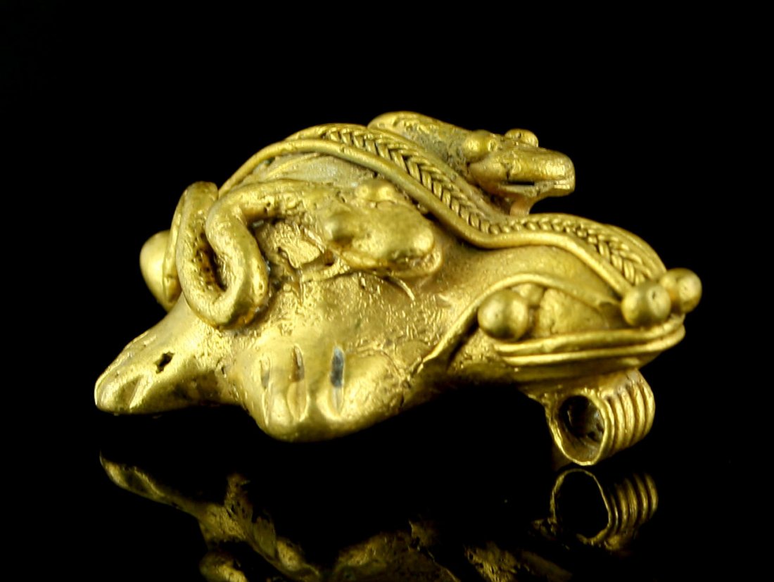 1 9/16" Tairona Gold Turtle Effigy Pendant: Nice small turtle weighing 13.1 grams and depicting two snakes riding on its back. Tumbago gold of unknown purity. Colombia.