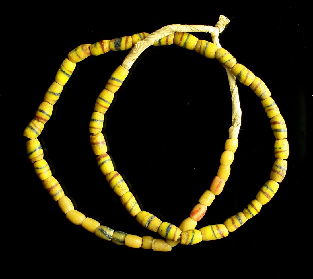 22" Trade Bead Necklace: Sand Cast Yellow striped beads. Strung on grass.