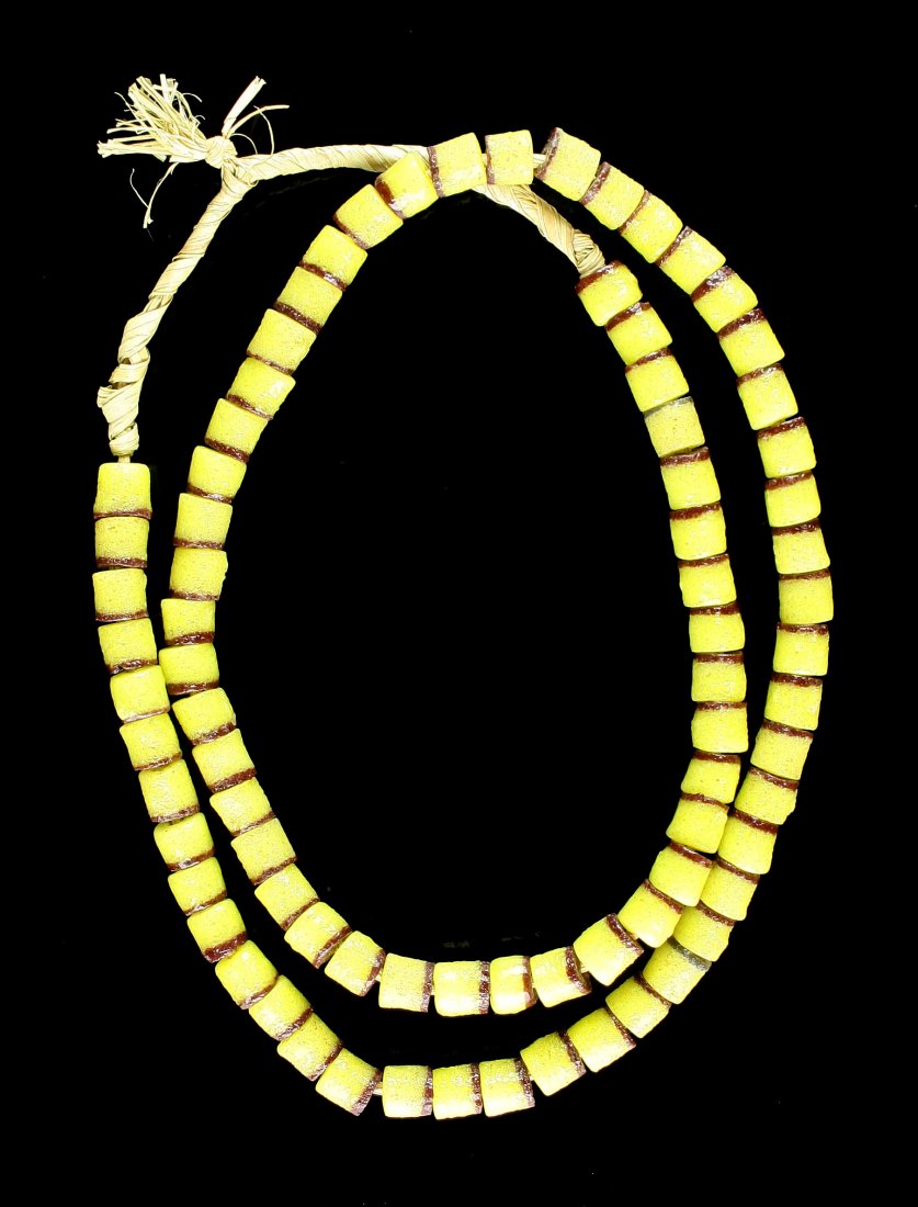 23" Beaded Necklace.: Sand cast yellow and brown beads. Unknown age. Strung on grass. Decorative.