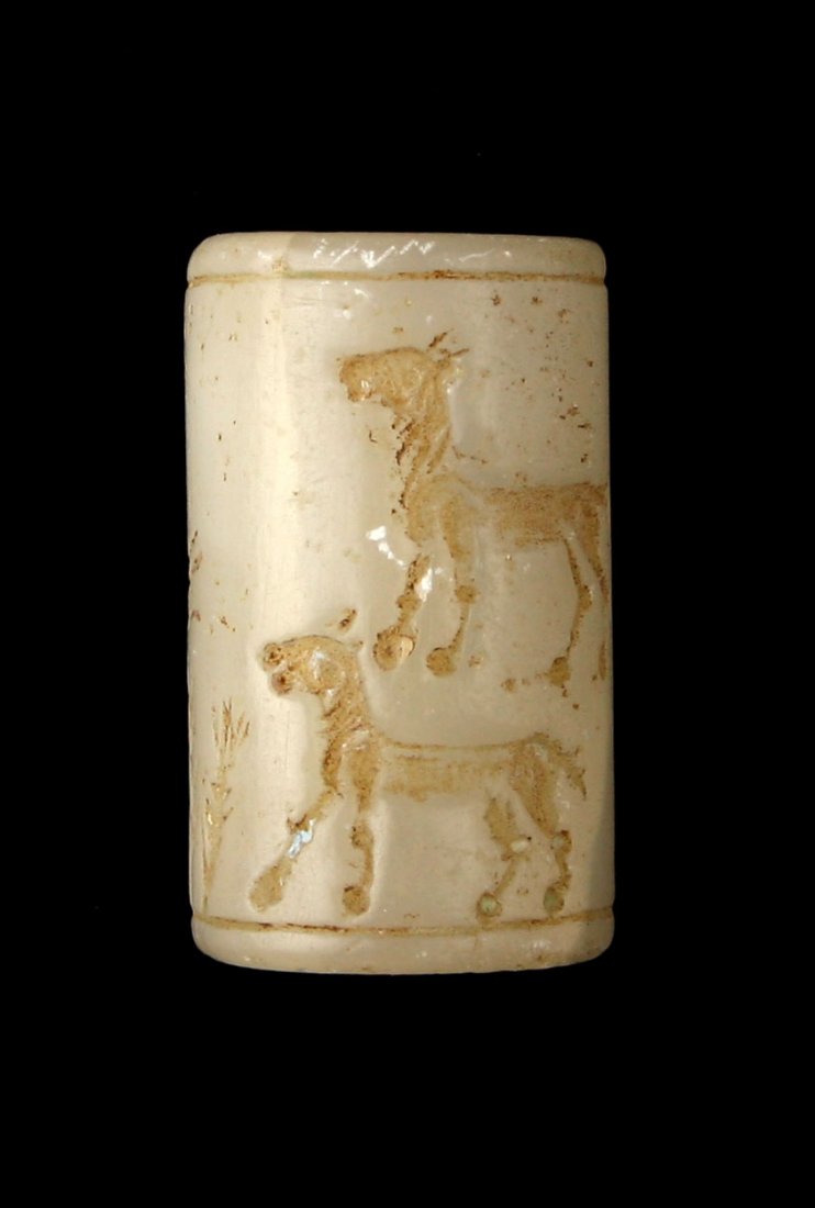 1 3/16" Western Asiatic Cylinder Seal: White agate example depicting two figures and two beasts. Formerly of the Tedder estate collection of Los Angeles.