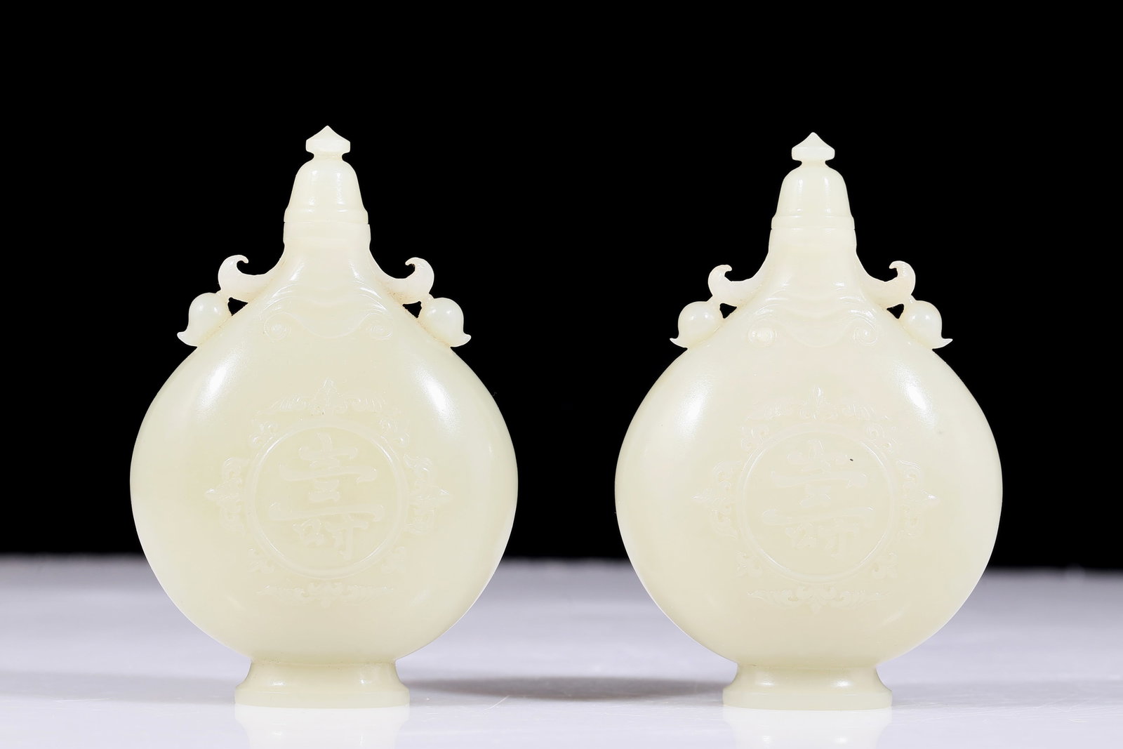 A pair of exquisite white jade amphora with floral patterns: pair of exquisite white jade flower-patterned amphora. The jade exhibits delicate, warm and lustrous qualities. The craftsmanship is flawless, the design is exquisite, and the carvings are exquisite,