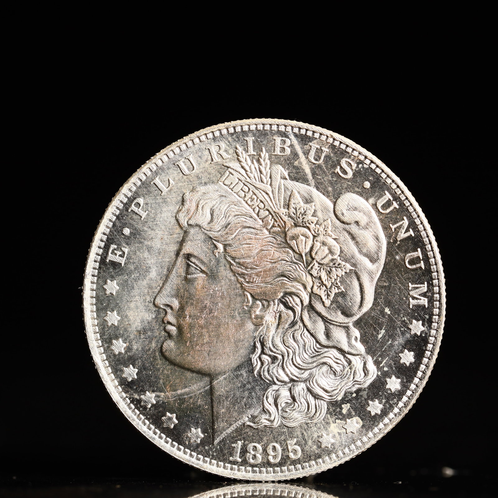 USA Morgan Dollar 1895 Coin: Obv: profile bust with date below and E PLURIBUS UNUM legend and stars around. Rev: eagle with In God we trust above within wreath with UNITED STATES OF AMERICA ONE DOLLAR legend. IN GOD WE TRUST / LI