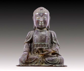 A solemn bronze statue of Gautama Buddha
