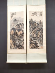 A pair of vertical scrolls of Chinese ink landscape painting on paper