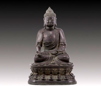 A solemn bronze statue of Gautama Buddha