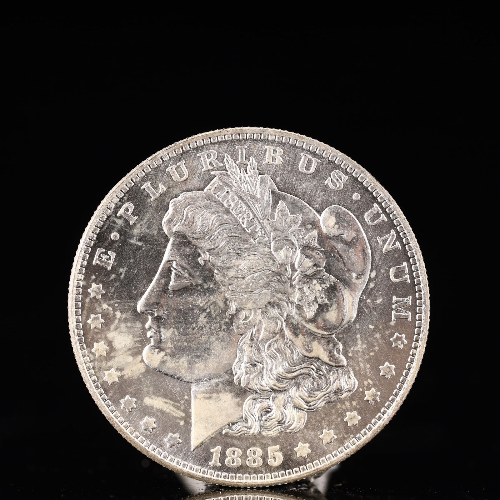 USA Morgan Dollar 1885 Coin: Obv: profile bust with date below and E PLURIBUS UNUM legend and stars around. Rev: eagle with In God we trust above within wreath with UNITED STATES OF AMERICA ONE DOLLAR legend. IN GOD WE TRUST / LI