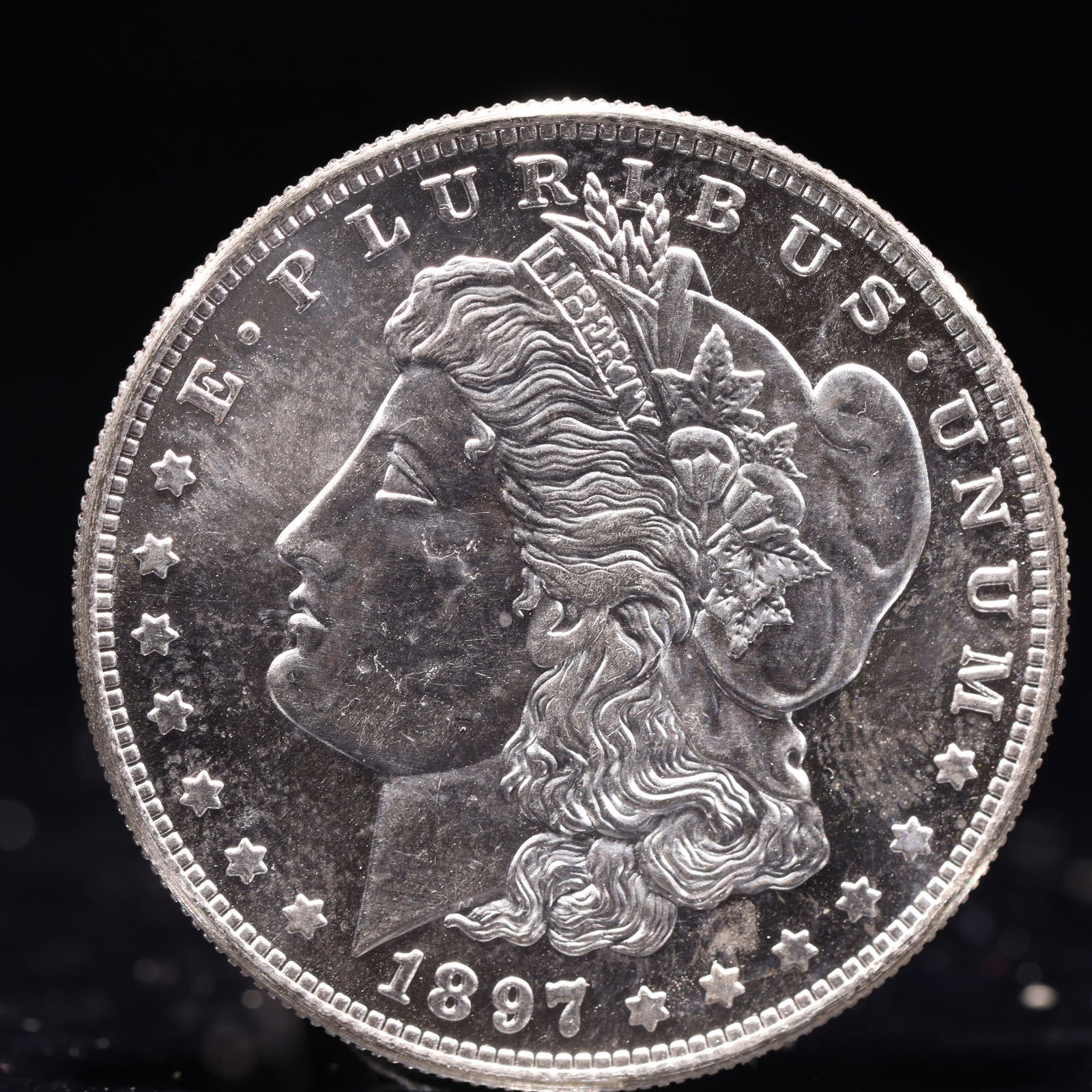 USA Morgan Dollar 1897 Coin: Obv: profile bust with date below and E PLURIBUS UNUM legend and stars around. Rev: eagle with In God we trust above within wreath with UNITED STATES OF AMERICA ONE DOLLAR legend. IN GOD WE TRUST / LI