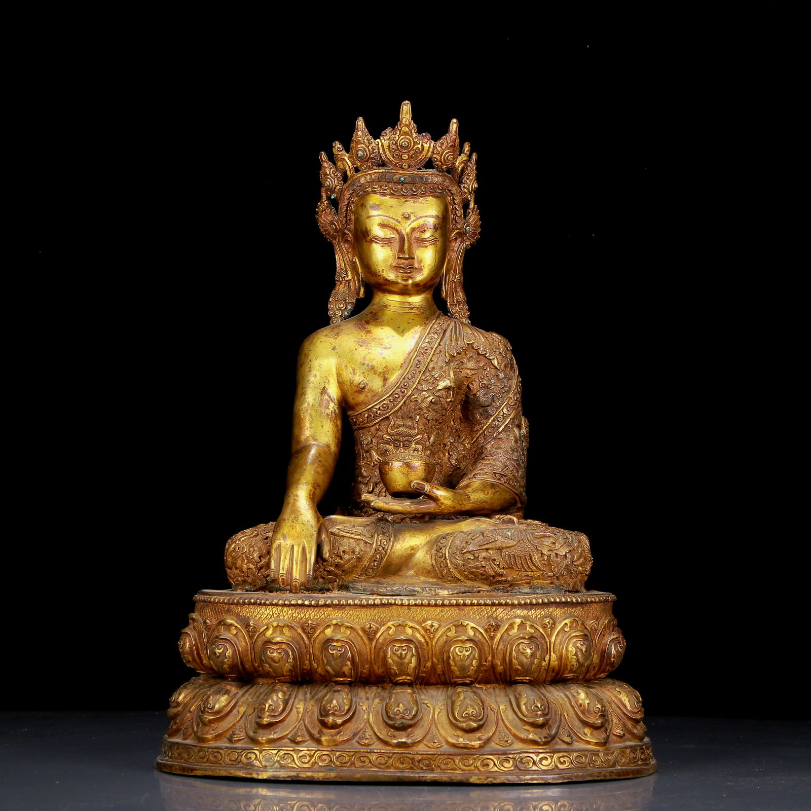 A huge gilt bronze statue of Sakyamuni: huge gilt bronze statue of Sakyamuni, Ming Dynasty, China. The Buddha's face has a calm, kind and serene expression, and his hands and fingers show beautiful lines and proportions to demonstrate the