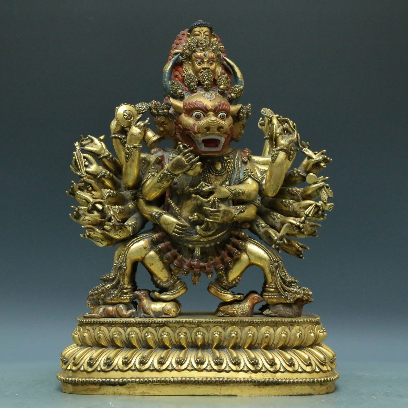 An Archaic Gilt-Bronze Figure Of Yamantaka Vajrabhairava: An Archaic Gilt-Bronze Figure Of Yamantaka Vajrabhairava. Feet stepped on mythical beasts and prostrating figures, topknot surmounted by miniature human masks, mouth open, revealing fangs. Chinese