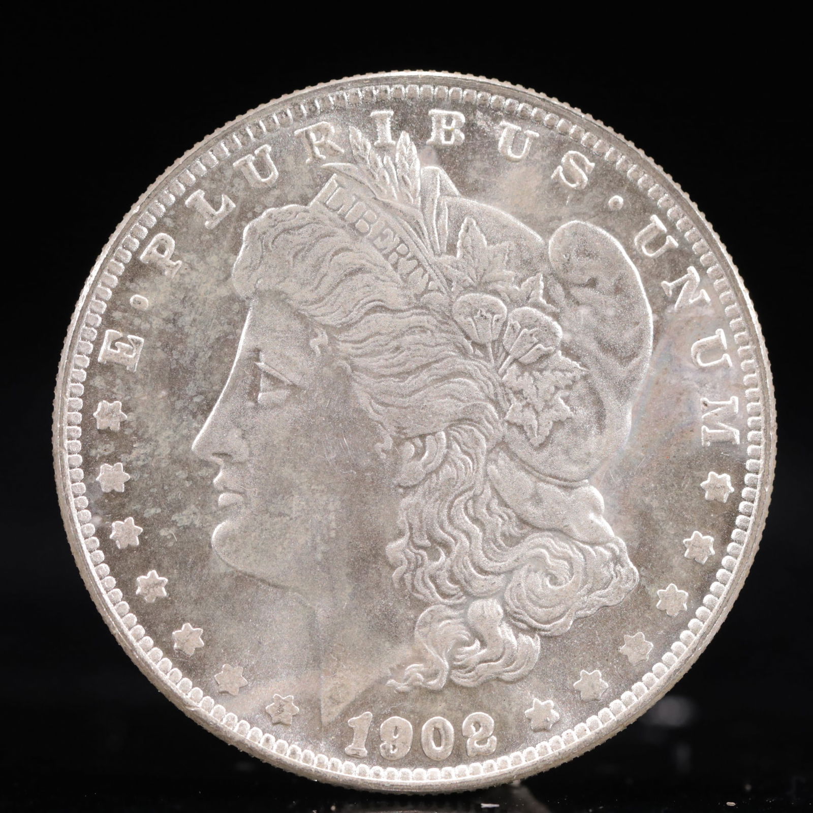 USA Morgan Dollar 1902 Coin: Obv: profile bust with date below and E PLURIBUS UNUM legend and stars around. Rev: eagle with In God we trust above within wreath with UNITED STATES OF AMERICA ONE DOLLAR legend. IN GOD WE TRUST /