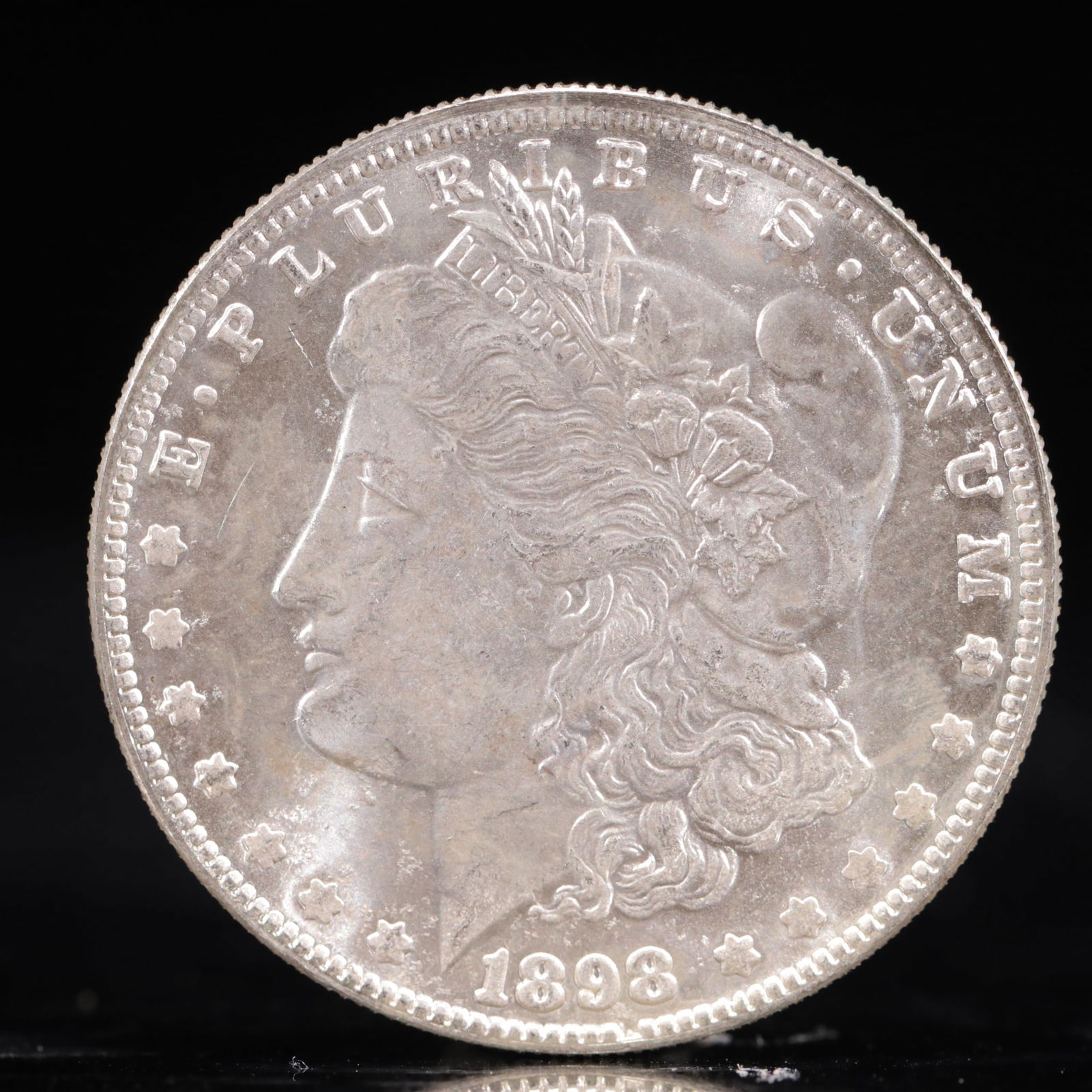 USA Morgan Dollar 1898 Coin: Obv: profile bust with date below and E PLURIBUS UNUM legend and stars around. Rev: eagle with In God we trust above within wreath with UNITED STATES OF AMERICA ONE DOLLAR legend. IN GOD WE TRUST /
